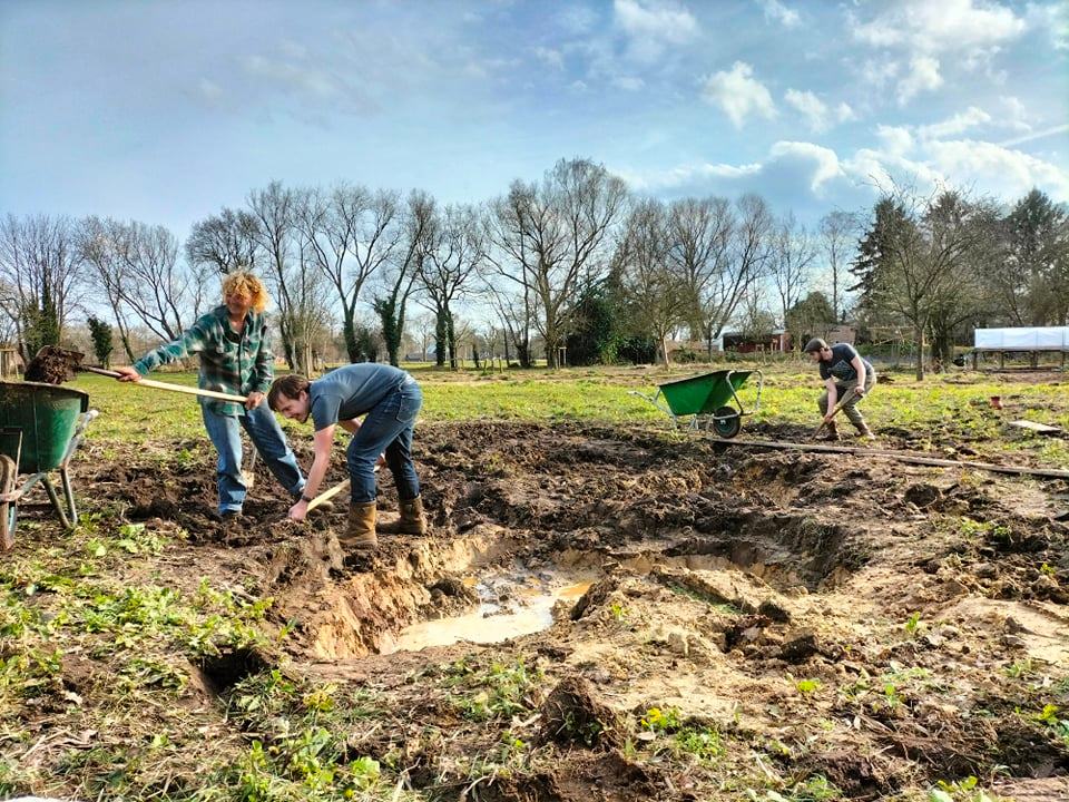 Voor dat de eerste groente de grond in konden moesten we veel werk verzetten. Hier zie je een aantal mensen enthousiast aan het werk.